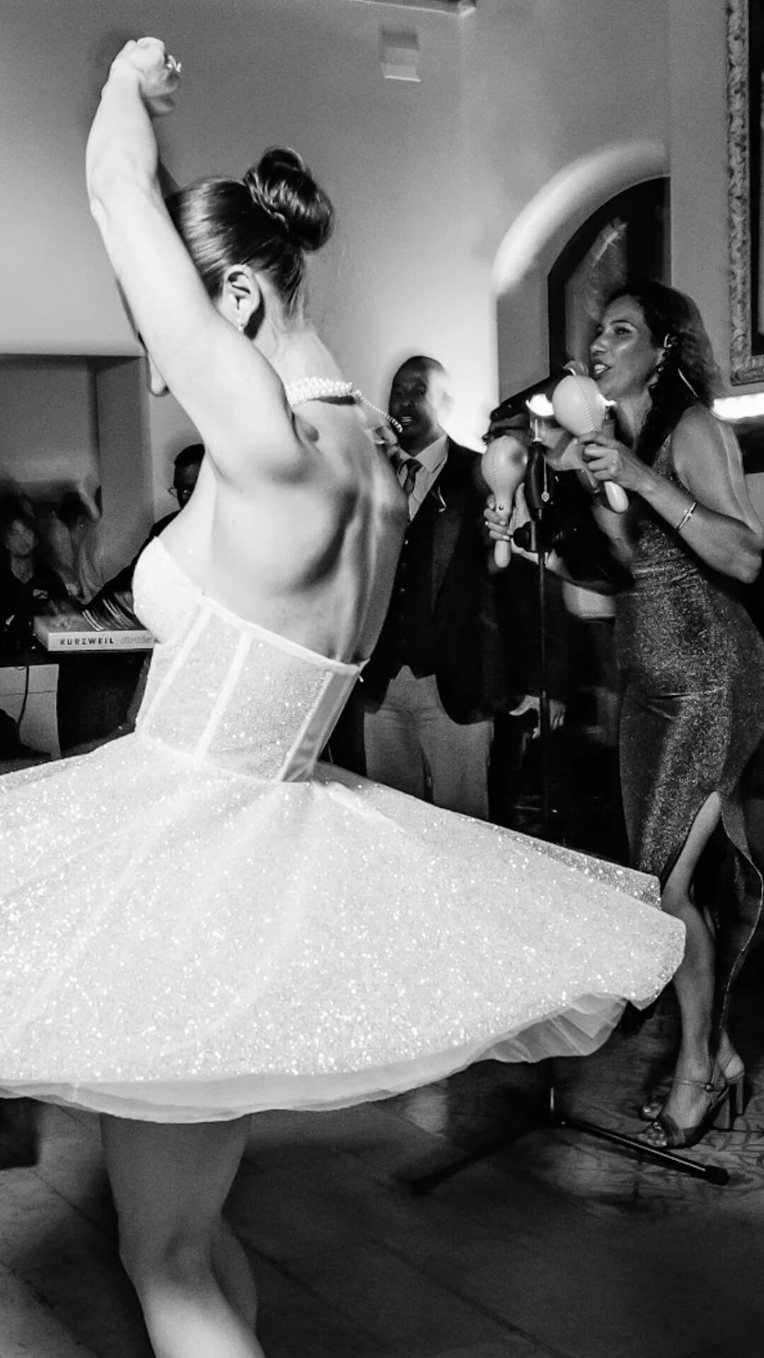 Live wedding band performing during a high-energy wedding party in Spain with guests dancing