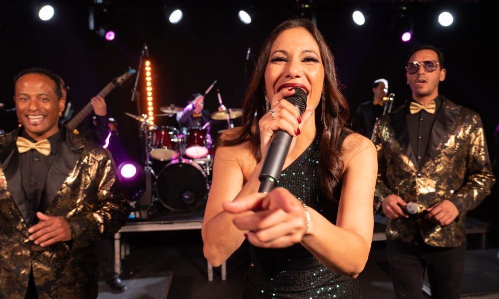 Professional wedding band performing live on stage in Spain with lead singer engaging the audience